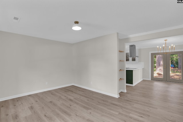 898 Perry Blvd, Sumter, SC 29154 - spare room featuring light wood finished floors, a chandelier, french doors, and ornamental molding