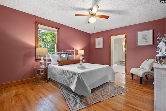 623 Hook Ave, West Columbia, SC 29169 - bedroom featuring wood finished floors, a textured ceiling, a ceiling fan, and connected bathroom