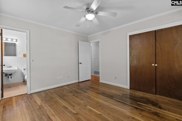 2017 Wellington Rd, Cayce, SC 29033 - unfurnished bedroom featuring wood-type flooring, ensuite bathroom, crown molding, a closet, and a ceiling fan