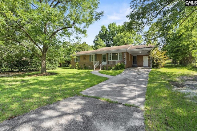 2017 Wellington Rd, Cayce, SC 29033 - ranch-style house featuring driveway, a carport, a porch, a front yard, and brick siding