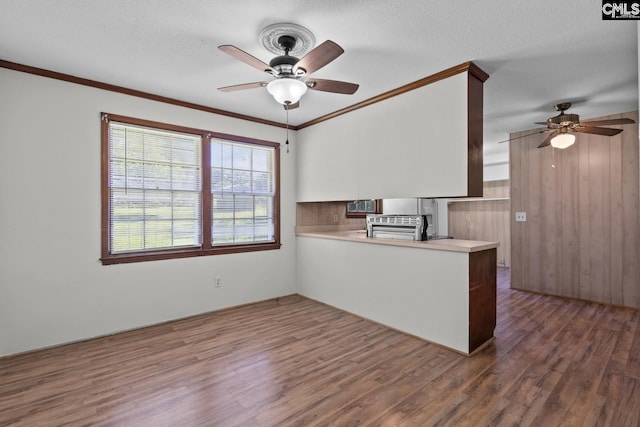 2017 Wellington Rd, Cayce, SC 29033 - kitchen featuring ceiling fan, wood finished floors, a peninsula, light countertops, and crown molding