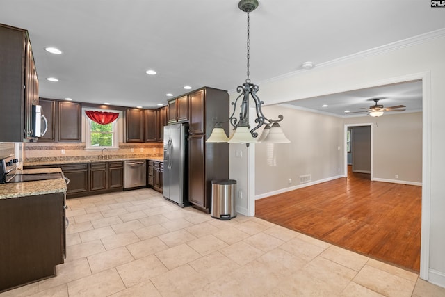 811 Rosedale Rd, West Columbia, SC 29170 - kitchen featuring appliances with stainless steel finishes, crown molding, tasteful backsplash, light stone countertops, and dark brown cabinets