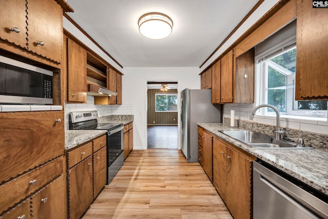 32 Nob Hill Rd, Columbia, SC 29210 - kitchen featuring stainless steel appliances, brown cabinets, light wood finished floors, backsplash, and under cabinet range hood