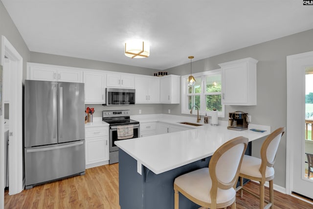 116 Laurel Rock Pt, Leesville, SC 29070 - kitchen with appliances with stainless steel finishes, light wood-style floors, white cabinetry, light countertops, and a kitchen breakfast bar