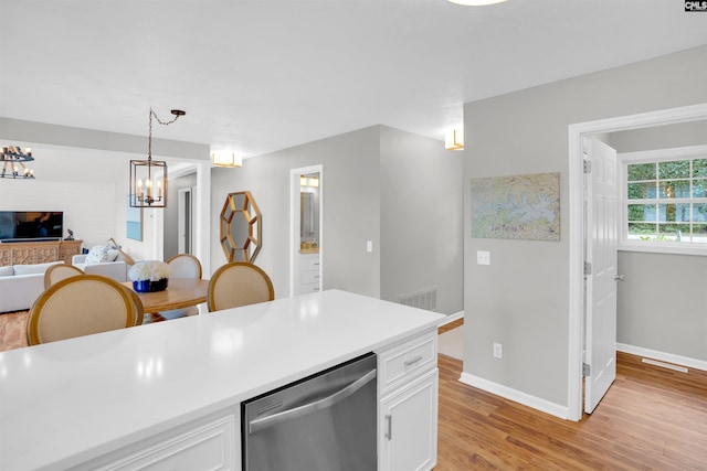 116 Laurel Rock Pt, Leesville, SC 29070 - kitchen with stainless steel dishwasher, white cabinets, light wood-style floors, a chandelier, and decorative light fixtures