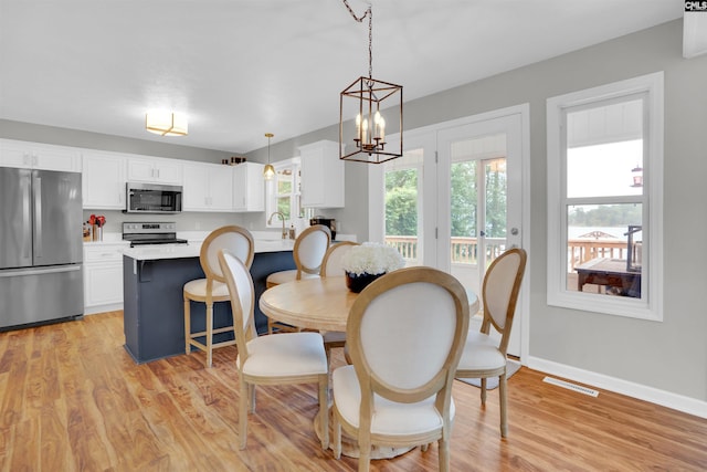 116 Laurel Rock Pt, Leesville, SC 29070 - dining area with light wood-style flooring and a chandelier