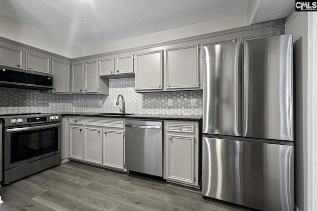 118 Tee Ct, Columbia, SC 29212 - kitchen featuring appliances with stainless steel finishes, dark countertops, a textured ceiling, dark wood-style flooring, and backsplash