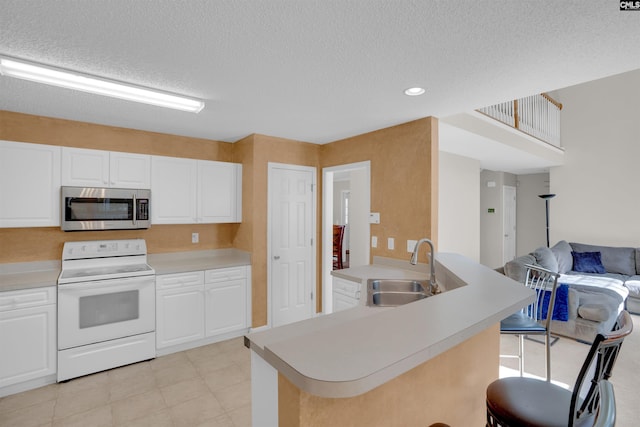 316 Founders Ridge Rd, Columbia, SC 29229 - kitchen with stainless steel microwave, white range with electric stovetop, open floor plan, a breakfast bar, and light countertops