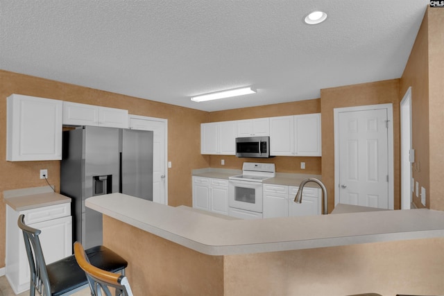 316 Founders Ridge Rd, Columbia, SC 29229 - kitchen featuring appliances with stainless steel finishes, light countertops, a breakfast bar area, white cabinetry, and a textured ceiling