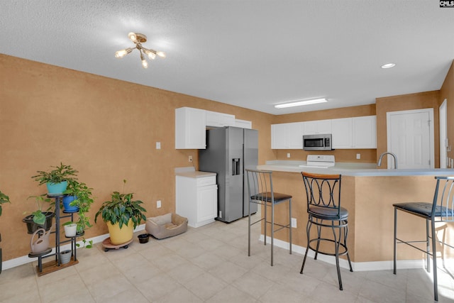 316 Founders Ridge Rd, Columbia, SC 29229 - kitchen featuring appliances with stainless steel finishes, light countertops, a kitchen breakfast bar, and white cabinetry