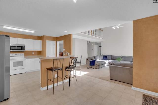 316 Founders Ridge Rd, Columbia, SC 29229 - kitchen featuring appliances with stainless steel finishes, a kitchen breakfast bar, white cabinets, open floor plan, and light countertops