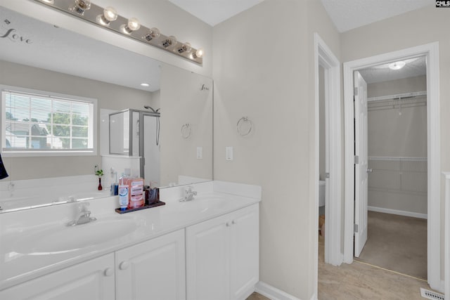 316 Founders Ridge Rd, Columbia, SC 29229 - bathroom featuring a stall shower, double vanity, a spacious closet, a garden tub, and a textured ceiling