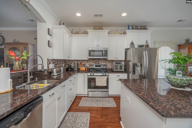 532 Ariel Cir, Lexington, SC 29072 - kitchen featuring appliances with stainless steel finishes, white cabinets, dark wood-type flooring, decorative backsplash, and crown molding