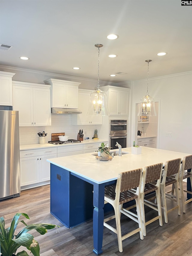 1324 Tamarind Ln, Chapin, SC 29036 - kitchen featuring stainless steel appliances, a breakfast bar area, ornamental molding, tasteful backsplash, and white cabinets