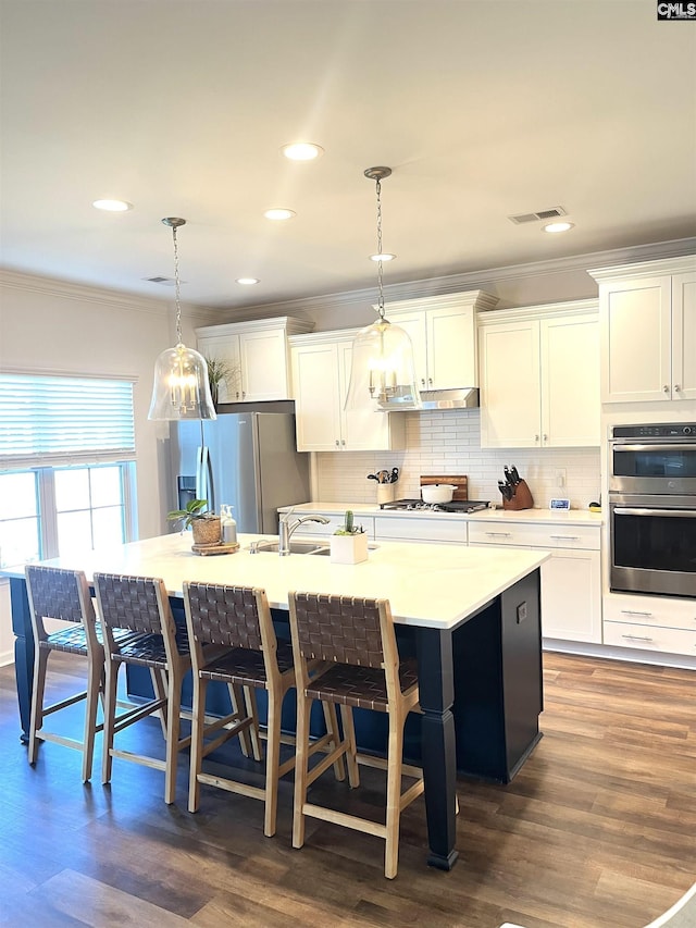 1324 Tamarind Ln, Chapin, SC 29036 - kitchen with appliances with stainless steel finishes, crown molding, a large island, tasteful backsplash, and white cabinets