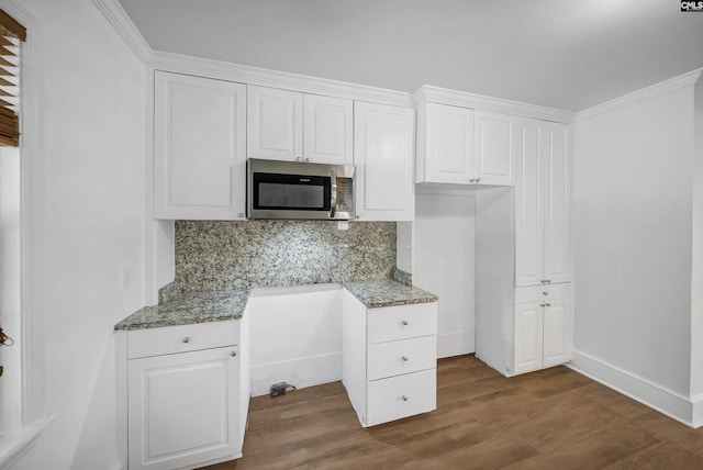 1005 D Ave, West Columbia, SC 29169 - kitchen featuring stainless steel microwave, decorative backsplash, white cabinets, dark wood-type flooring, and light stone countertops
