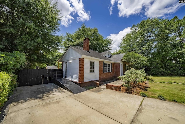 1005 D Ave, West Columbia, SC 29169 - view of property exterior featuring a chimney, brick siding, and a patio area