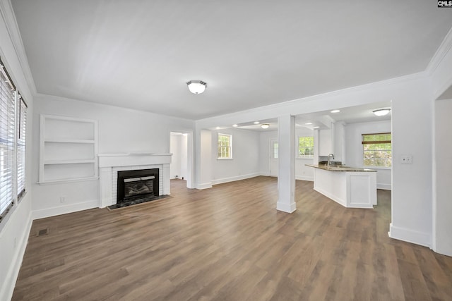 1005 D Ave, West Columbia, SC 29169 - unfurnished living room with crown molding, dark wood-style floors, a fireplace, and built in features