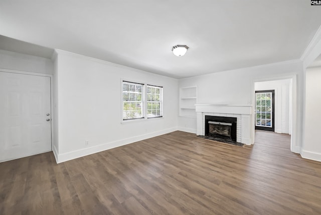 1005 D Ave, West Columbia, SC 29169 - unfurnished living room with ornamental molding, built in shelves, healthy amount of natural light, dark wood-style floors, and a fireplace