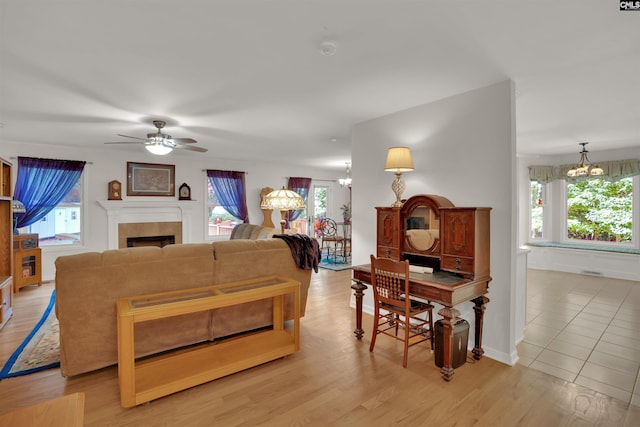 1176 Whippoorwill Rd, Prosperity, SC 29127 - living room featuring ceiling fan, a chandelier, a tiled fireplace, and light wood finished floors