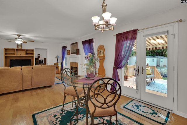1176 Whippoorwill Rd, Prosperity, SC 29127 - dining room featuring a chandelier, light wood finished floors, a ceiling fan, a fireplace, and french doors
