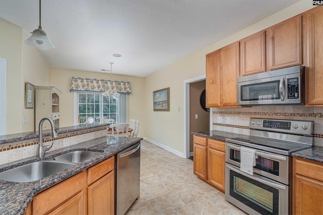 5 Blue Mountain Ct, Irmo, SC 29063 - kitchen featuring appliances with stainless steel finishes, tasteful backsplash, hanging light fixtures, dark stone counters, and a textured ceiling