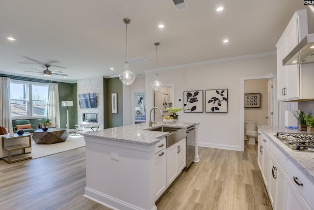 821 Oak Valley Dr, Blythewood, SC 29016 - kitchen with stainless steel appliances, wall chimney range hood, ceiling fan, a stone fireplace, and open floor plan