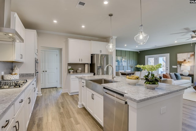 821 Oak Valley Dr, Blythewood, SC 29016 - kitchen with appliances with stainless steel finishes, wall chimney exhaust hood, open floor plan, a ceiling fan, and crown molding