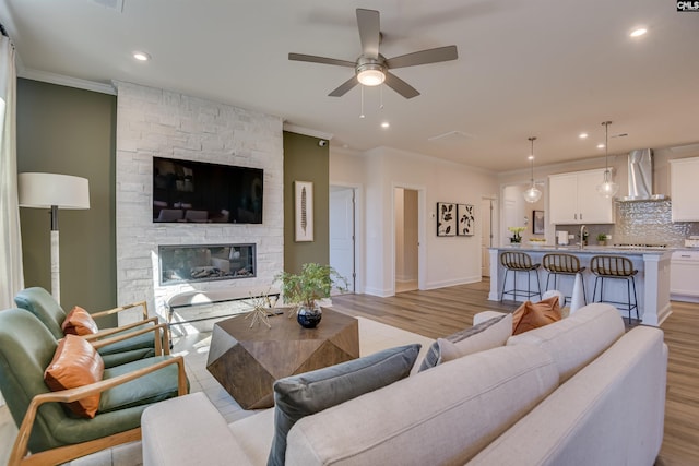 821 Oak Valley Dr, Blythewood, SC 29016 - living area featuring ornamental molding, ceiling fan, a stone fireplace, light wood-style floors, and recessed lighting