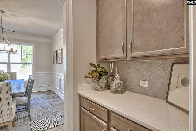 793 Oak Valley Dr, Blythewood, SC 29016 - bar with crown molding, tasteful backsplash, a chandelier, wood finished floors, and a decorative wall