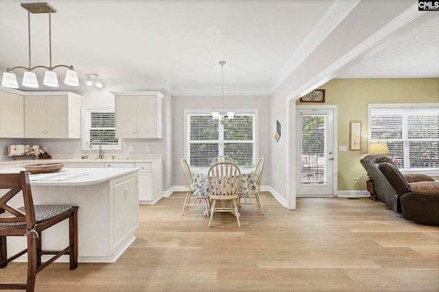 113 Chalfont Ln, Columbia, SC 29229 - kitchen with light countertops, a kitchen bar, light wood-type flooring, white cabinetry, and hanging light fixtures