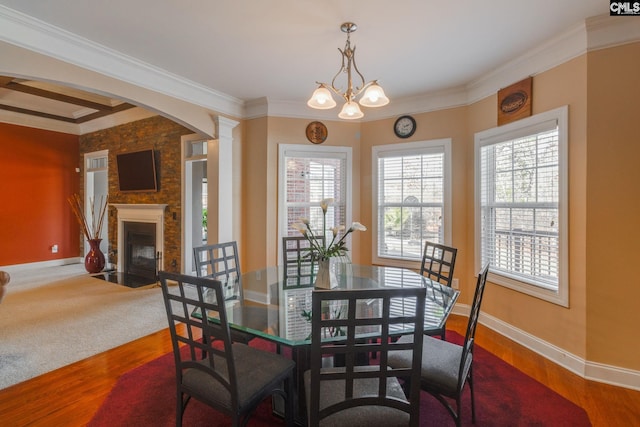 340 Heritage Forest Dr, Blythewood, SC 29045 - dining space with healthy amount of natural light, a fireplace, wood finished floors, arched walkways, and crown molding