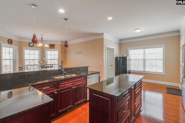 340 Heritage Forest Dr, Blythewood, SC 29045 - kitchen with reddish brown cabinets, light wood-style floors, hanging light fixtures, plenty of natural light, and ornamental molding