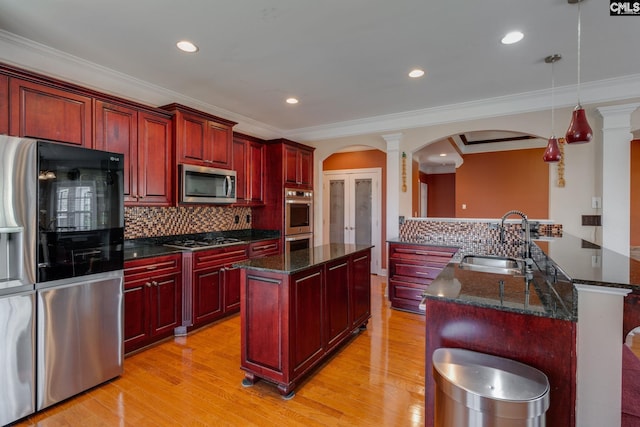 340 Heritage Forest Dr, Blythewood, SC 29045 - kitchen with stainless steel appliances, dark brown cabinets, a kitchen island, arched walkways, and backsplash