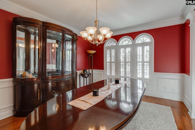 340 Heritage Forest Dr, Blythewood, SC 29045 - dining space with a chandelier, wainscoting, ornamental molding, wood finished floors, and a decorative wall