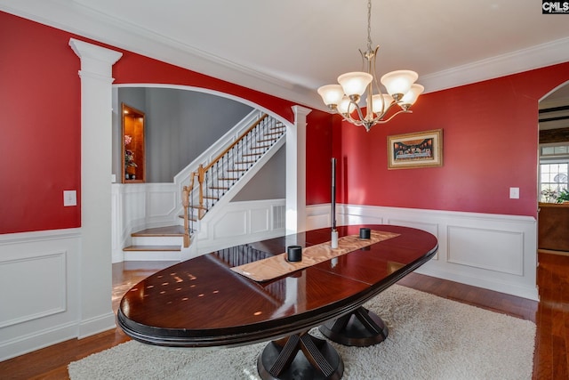 340 Heritage Forest Dr, Blythewood, SC 29045 - dining space featuring wood finished floors, a decorative wall, a chandelier, stairway, and a wainscoted wall