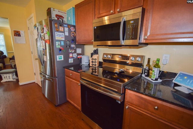458 Laurel Mist Ln, West Columbia, SC 29170 - kitchen featuring appliances with stainless steel finishes, dark wood-style flooring, dark stone countertops, and brown cabinetry