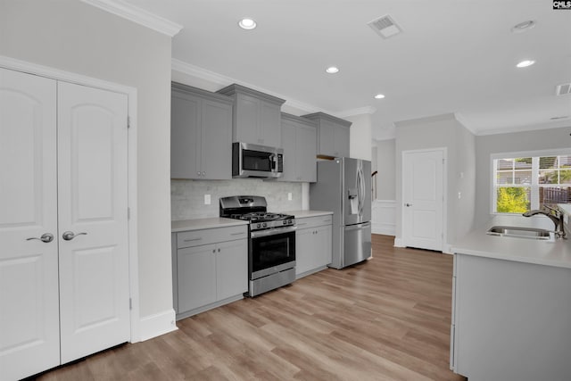 386 Amalfi Dr, Chapin, SC 29036 - kitchen with appliances with stainless steel finishes, crown molding, gray cabinets, decorative backsplash, and light countertops