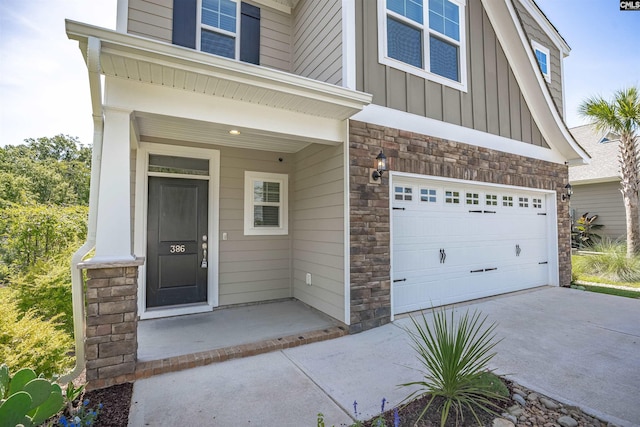 386 Amalfi Dr, Chapin, SC 29036 - doorway to property with stone siding, board and batten siding, a garage, and driveway