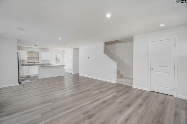 1021 Bermuda Cedar Ln, Hopkins, SC 29061 - unfurnished living room with light wood finished floors, stairs, and recessed lighting
