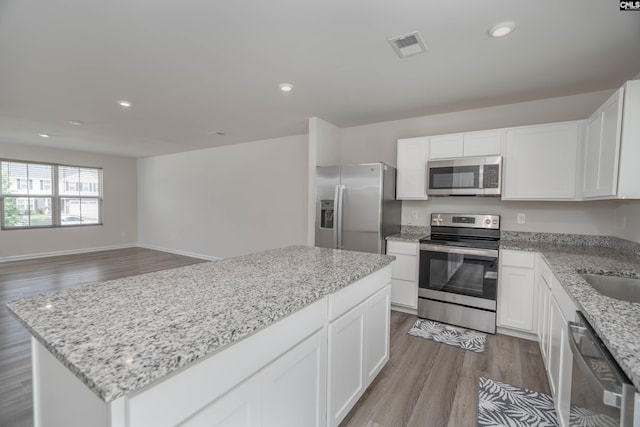 1021 Bermuda Cedar Ln, Hopkins, SC 29061 - kitchen with appliances with stainless steel finishes, wood finished floors, light stone countertops, white cabinets, and recessed lighting