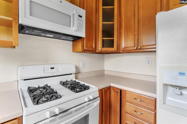 1400 Axtell Dr, Cayce, SC 29033 - kitchen featuring white appliances, light countertops, glass insert cabinets, and brown cabinets