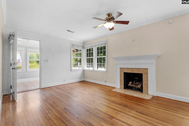 1400 Axtell Dr, Cayce, SC 29033 - unfurnished living room featuring hardwood / wood-style flooring, a ceiling fan, a tiled fireplace, and crown molding