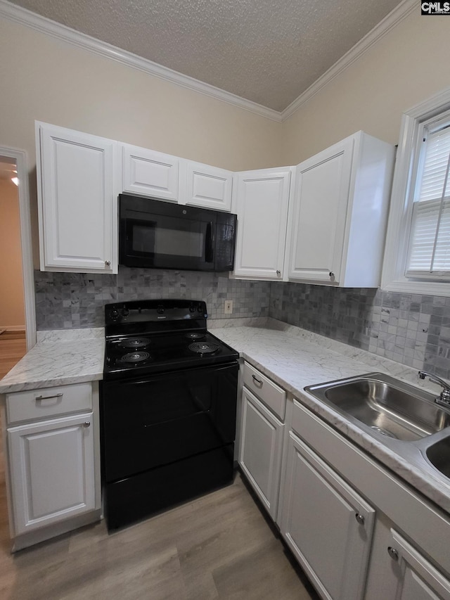 337 Mill St, Batesburg, SC 29006 - kitchen featuring black appliances, light wood-type flooring, white cabinetry, decorative backsplash, and crown molding