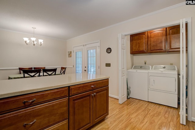 122 Halling Dr, Columbia, SC 29229 - laundry area with cabinet space, washer and clothes dryer, light wood-style flooring, ornamental molding, and a chandelier