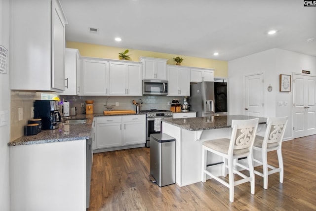 1420 Fair Forest Ln, Chapin, SC 29036 - kitchen with appliances with stainless steel finishes, white cabinetry, a breakfast bar area, a kitchen island, and recessed lighting