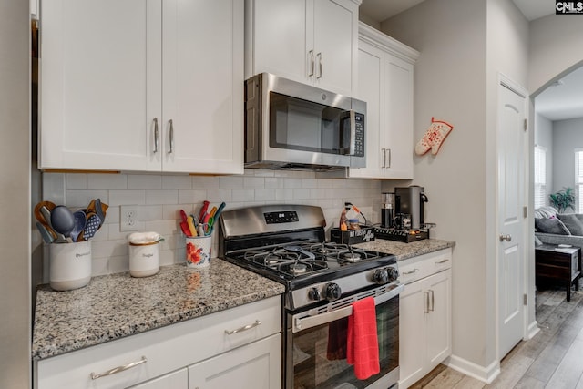 1013 Ashcroft Cir, Columbia, SC 29229 - kitchen featuring stainless steel appliances, light wood finished floors, white cabinetry, decorative backsplash, and light stone countertops