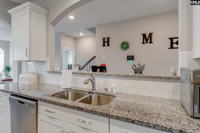 1013 Ashcroft Cir, Columbia, SC 29229 - kitchen with dishwasher, backsplash, arched walkways, white cabinetry, and light stone counters