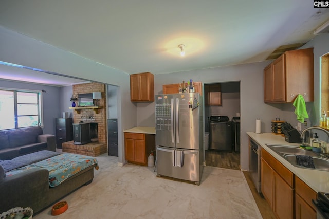 1206 Furman Dr, Sumter, SC 29154 - kitchen with freestanding refrigerator, washing machine and clothes dryer, dishwashing machine, brown cabinetry, and light countertops