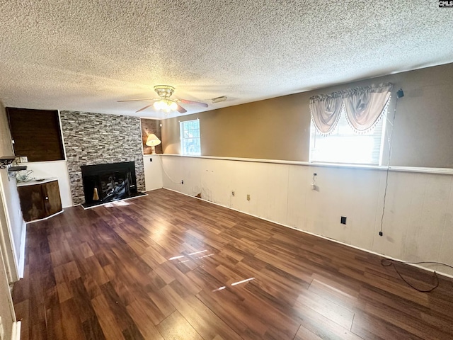 121 Durham Creek Ct, Columbia, SC 29229 - unfurnished living room with a textured ceiling, wood finished floors, a ceiling fan, a fireplace, and a wainscoted wall